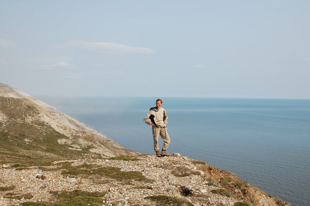 A woman standing on a cliff overlooking the Franklin Bay in the summer.