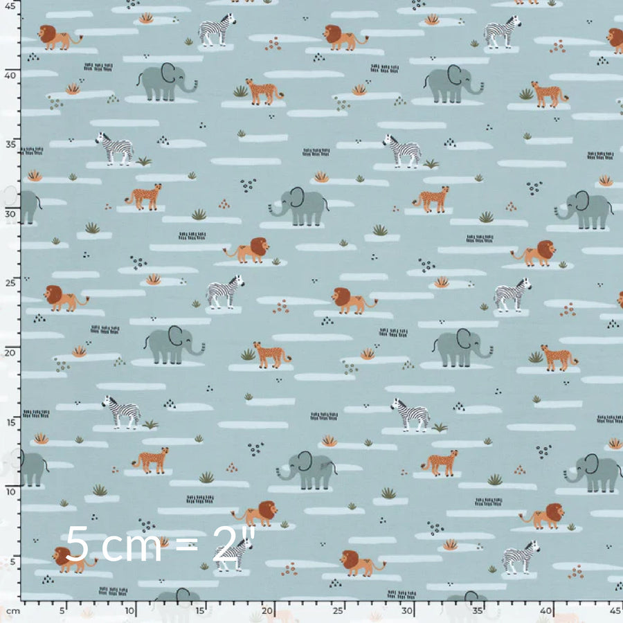 Fabric swatch showing cute children's print of African animals on a pale blue mint background with ruler for scale