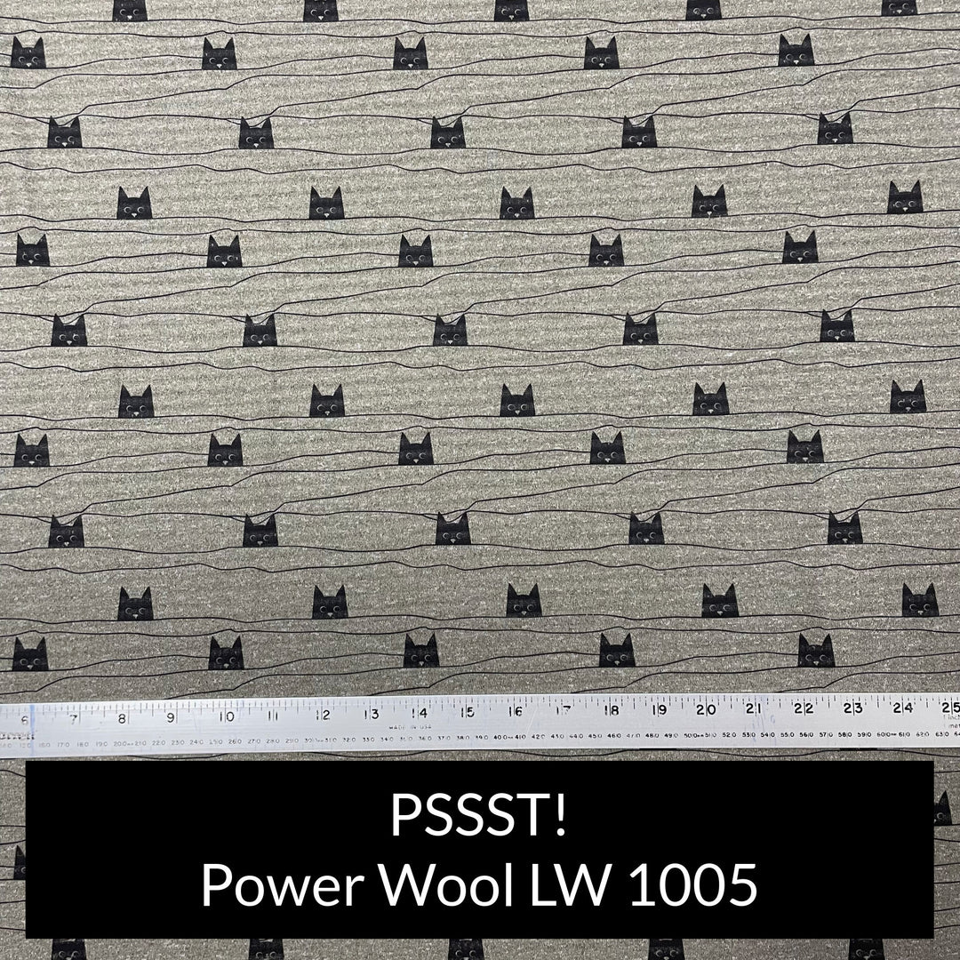 polartec power wool lightweight in heather grey green with a cute print of cartoon black cat faces peaking over a thin black line