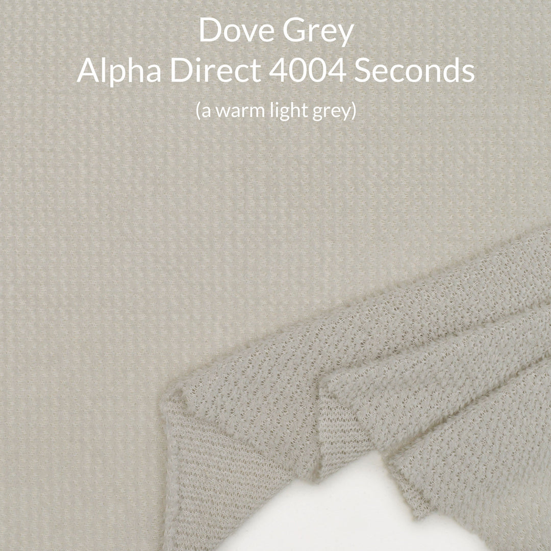 A close-up fabric swatch of Polartec Alpha Direct fabric in a warm light grey, with overlaid text reading 'Dove Grey Alpha Direct 4004 Seconds (a warm light grey)'.