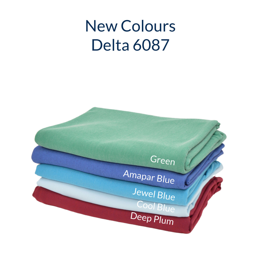 lifestyle image of a stack of green blue aqua pale blue and deep plum delta fabric