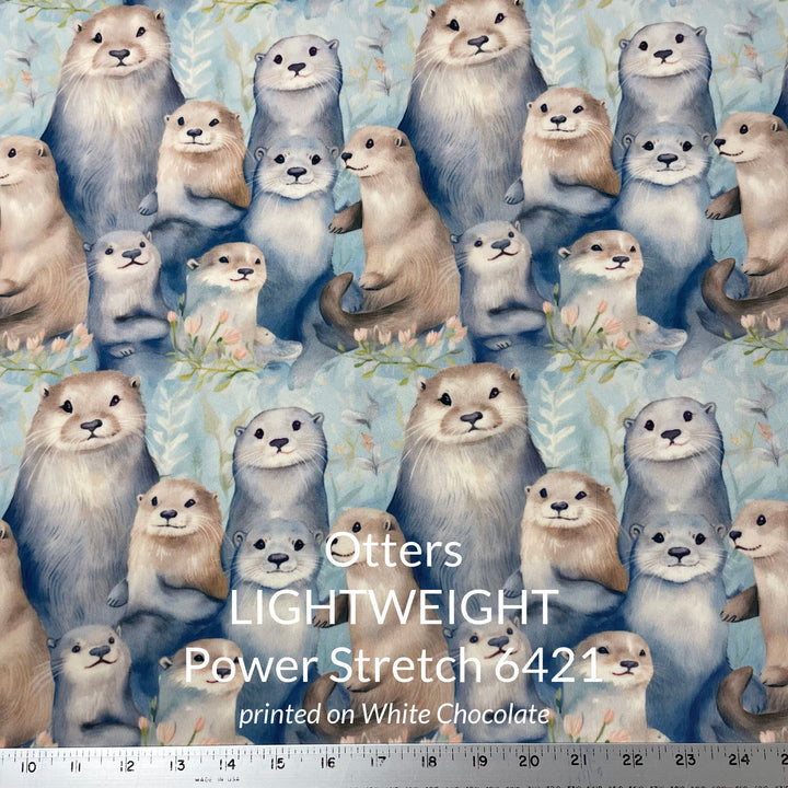 A cute print of otters in shades of tan taupe grey and blue on a water colour blue background printed on polartec power stretch fleece