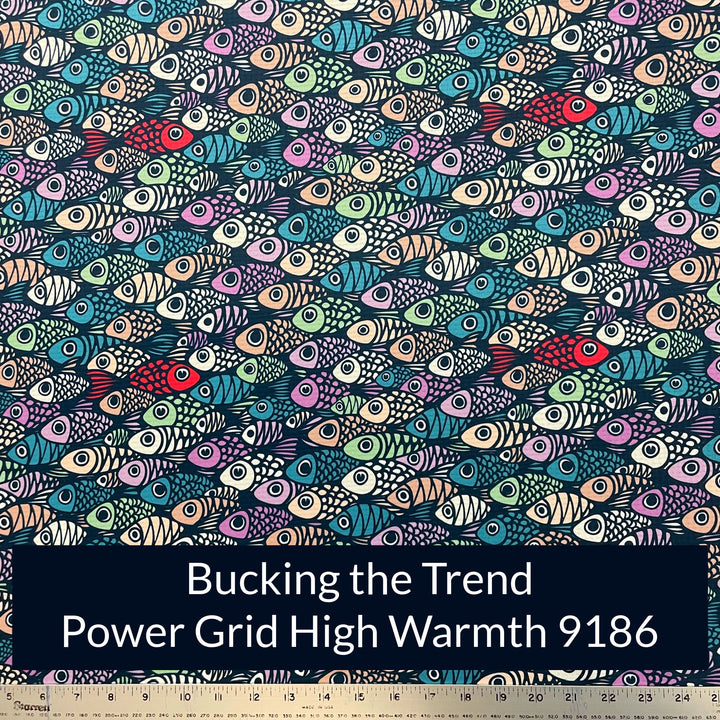 a print on polartec power grid high warmth fabric of cartoon fishes in mutiple shades of teal purple off white and peach with a few red fish swimming in the opposite direction