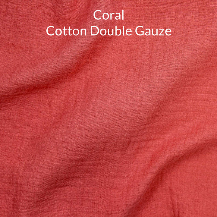 Close-up of coral-colored cotton double gauze fabric with text overlay.