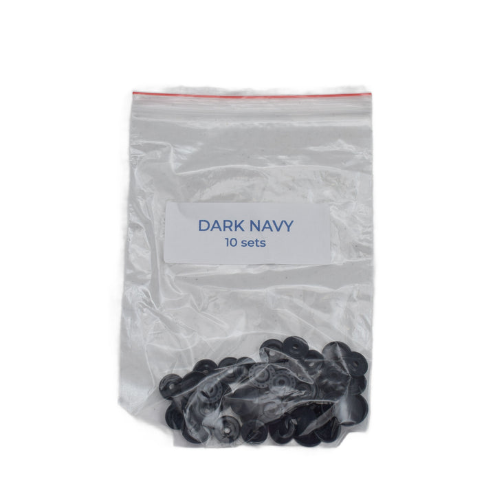 A clear plastic zip-top bag with a white label reading 'DARK NAVY 10 sets' containing dark navy size T5 round snap pieces, photographed on a white background.