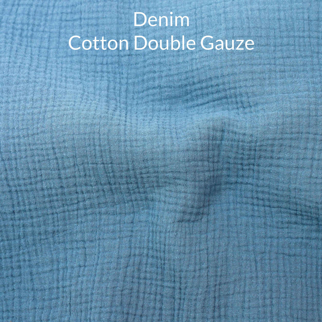 Close-up of denim blue-colored cotton double gauze fabric with text overlay.