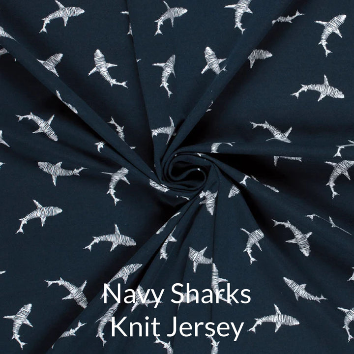 Fabric swatch of cute children's print of white sharks on a navy background