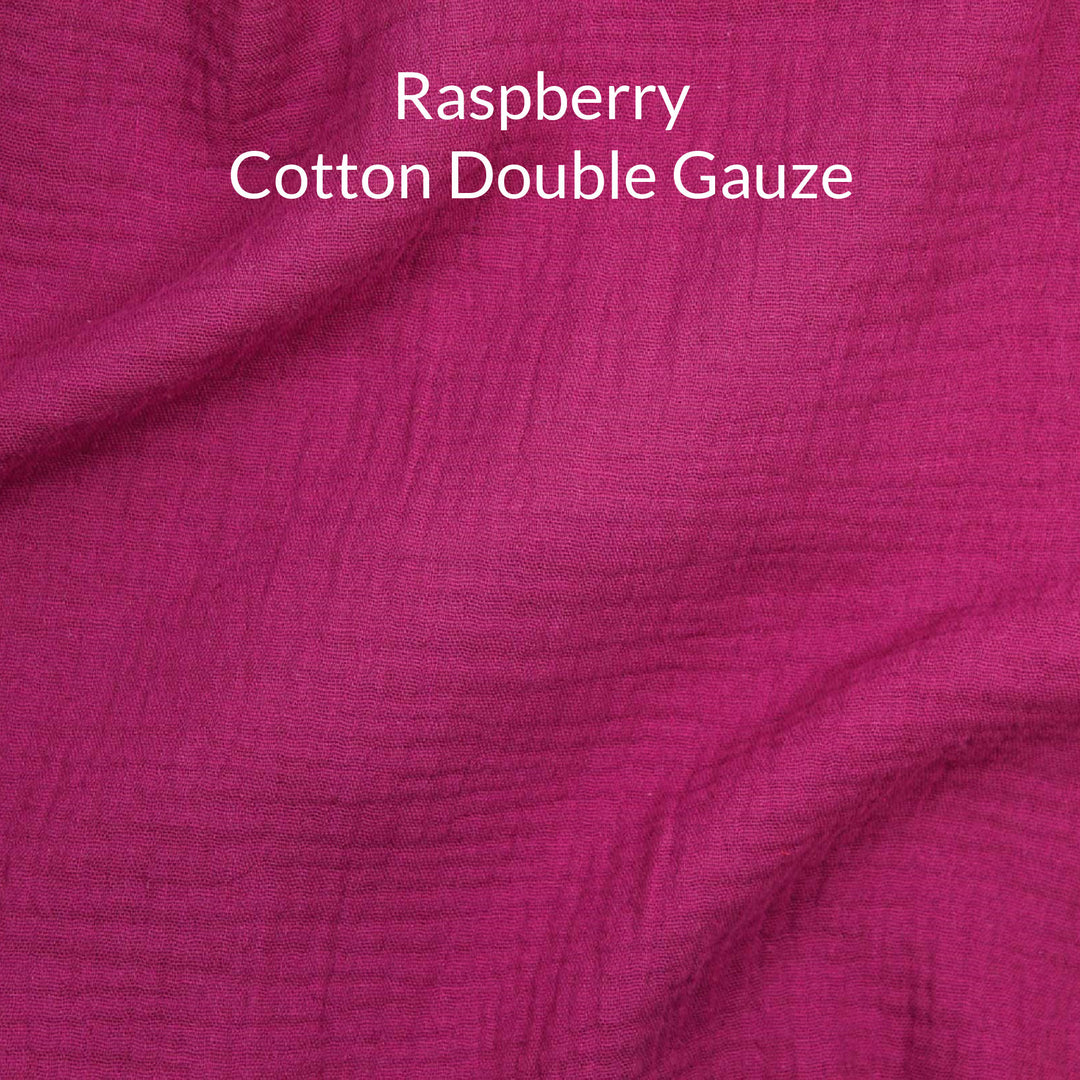 Close-up of raspberry dark pink-colored cotton double gauze fabric with text overlay.