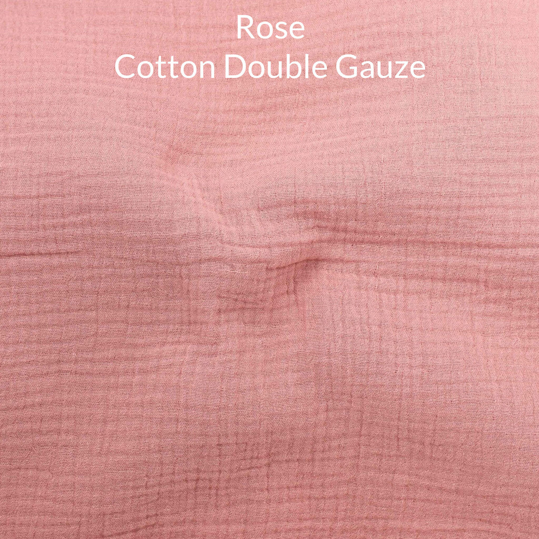 Close-up of a soft pink rose-colored cotton double gauze fabric with text overlay.