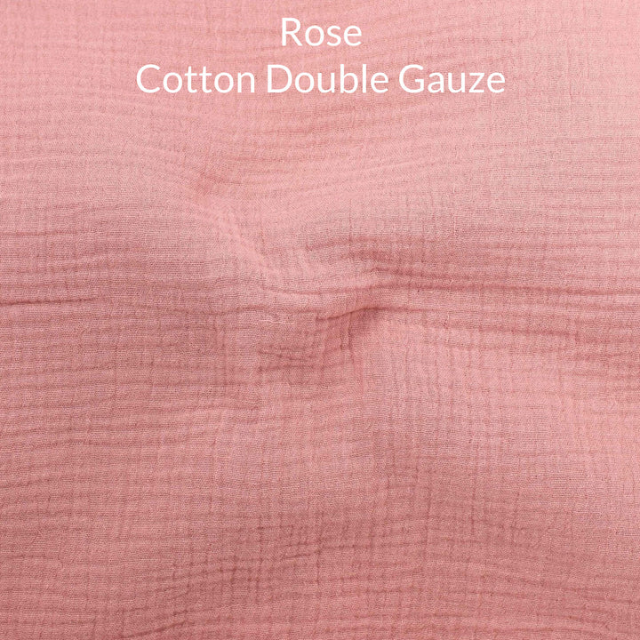Close-up of a soft pink rose-colored cotton double gauze fabric with text overlay.