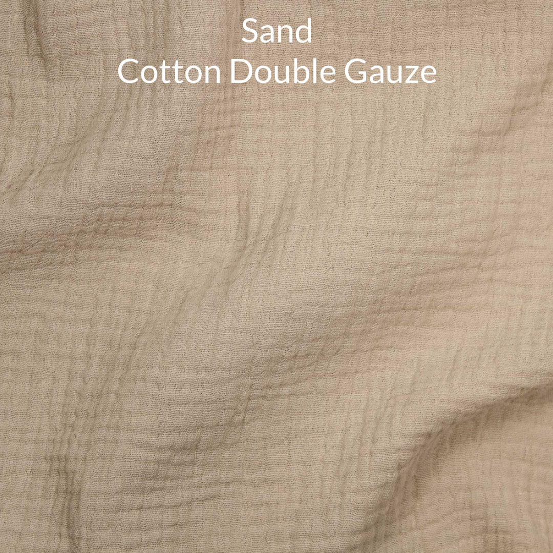 Close-up of sand-colored cotton double gauze fabric with text overlay.
