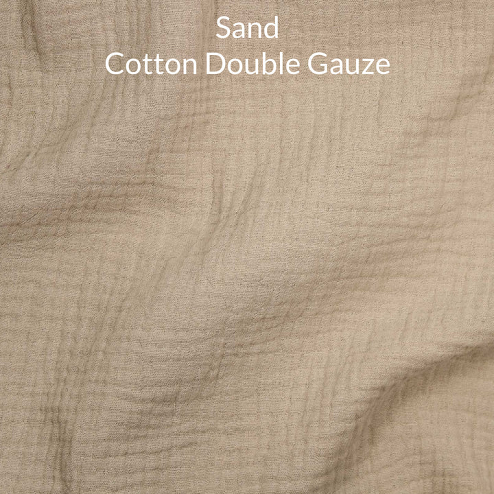 Close-up of sand-colored cotton double gauze fabric with text overlay.