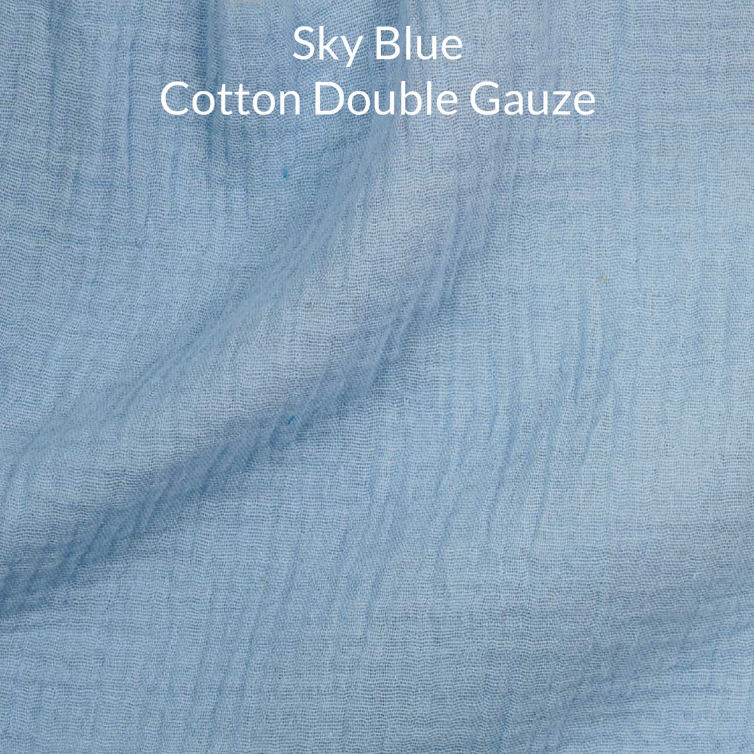 Close-up of sky blue cotton double gauze fabric with text overlay.