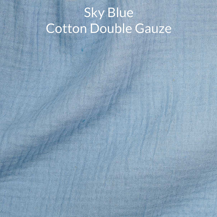 Close-up of sky blue cotton double gauze fabric with text overlay.