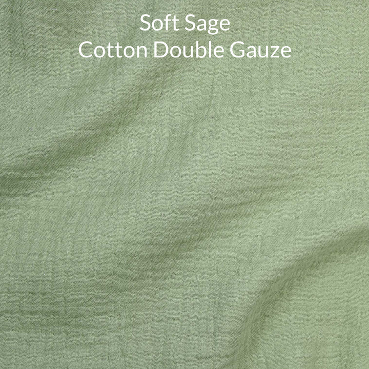 Close-up of soft sage green-colored cotton double gauze fabric with text overlay.