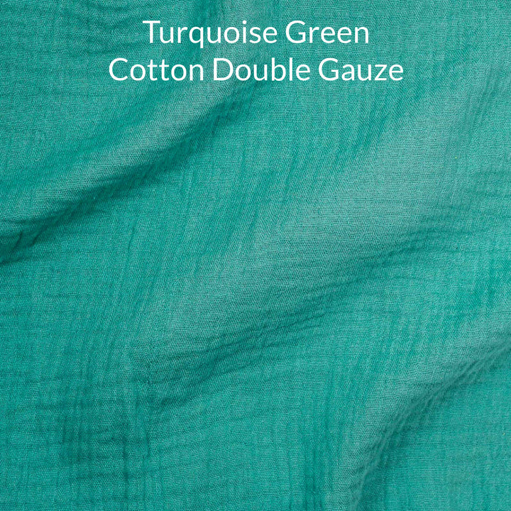 Turquoise green cotton double gauze fabric with text overlay