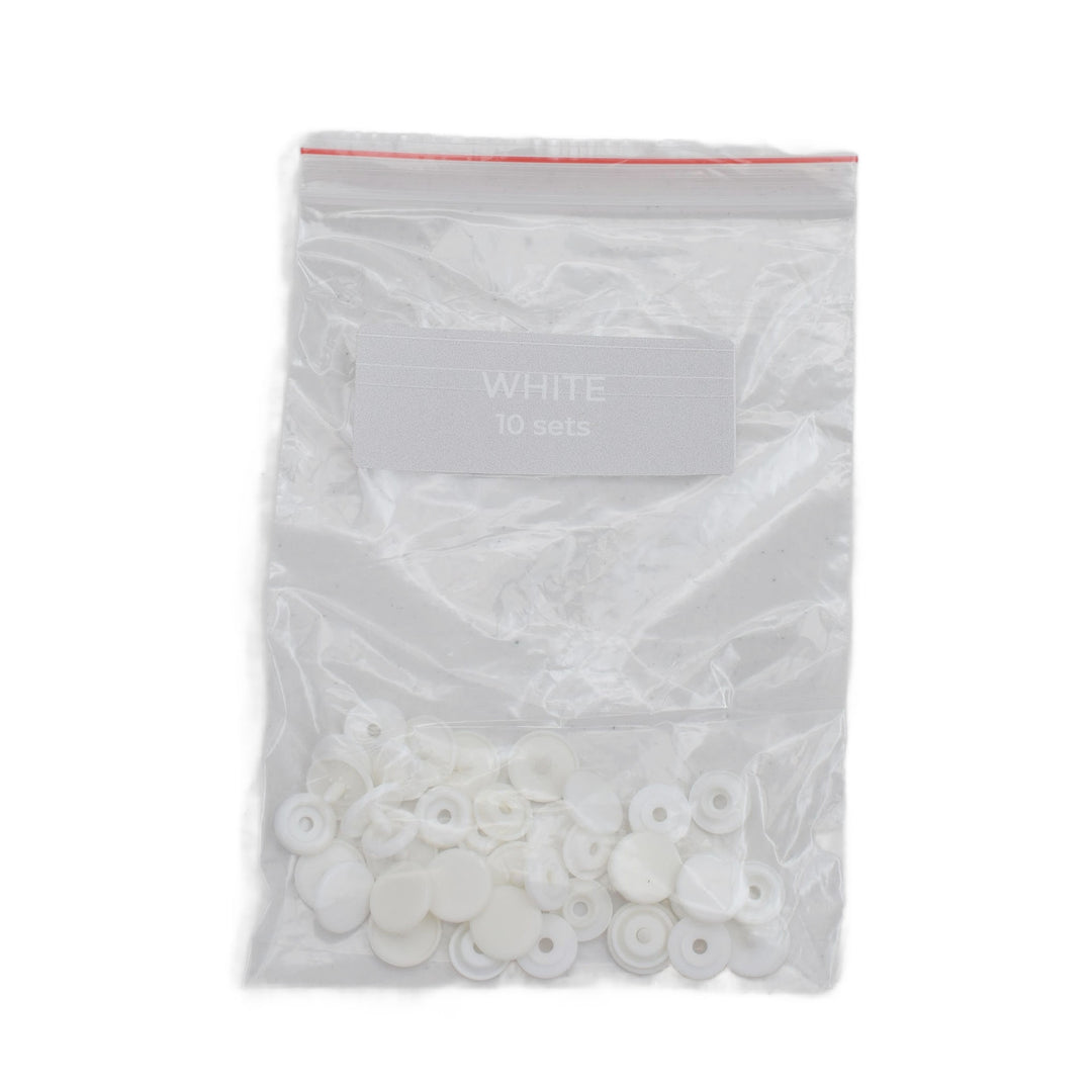 A clear plastic zip-top bag containing small white circular plastic snap pieces, with a label reading 'WHITE 10 sets' on a plain white background.