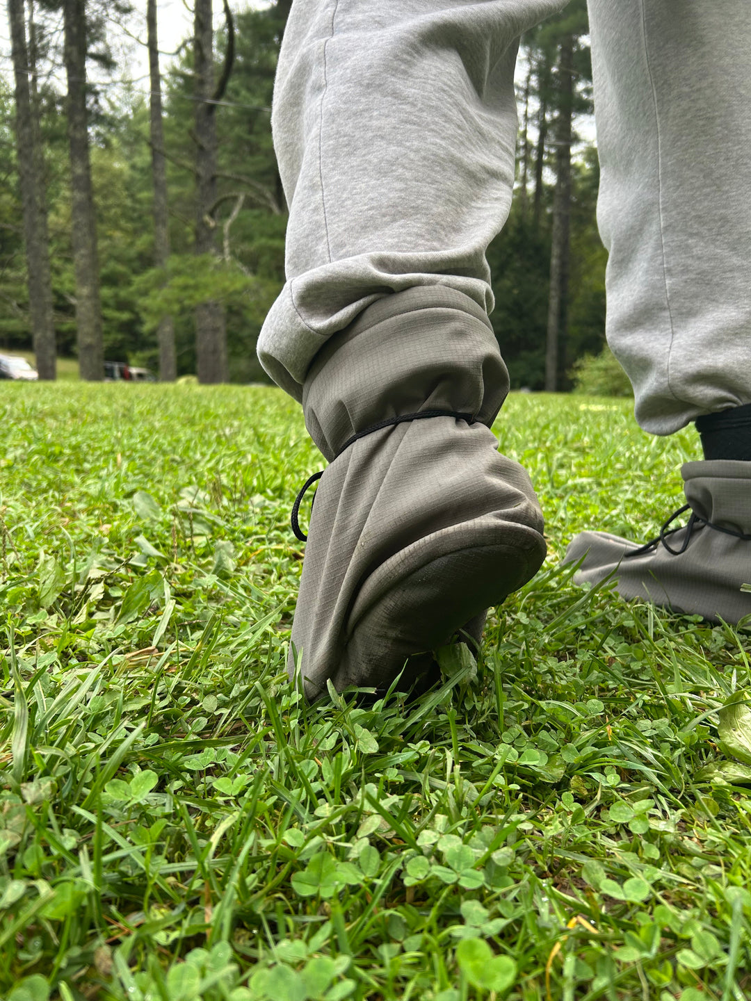 Person wearing a gray pants with high cuffs in a grassy area