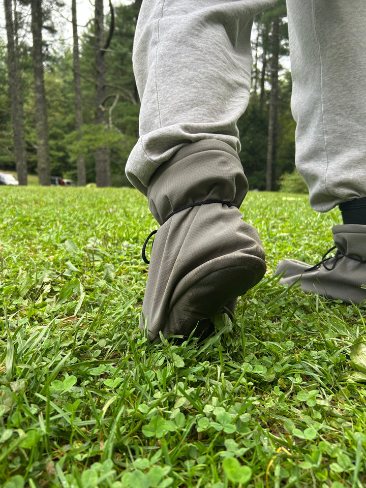 Person wearing a gray pants with high cuffs in a grassy area