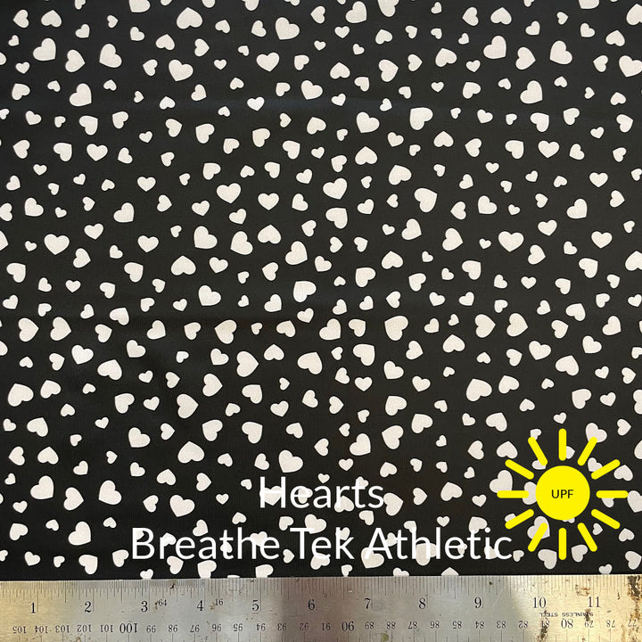 small multi sized white hearts on a black background of breathe tek sun protective athletic fabric