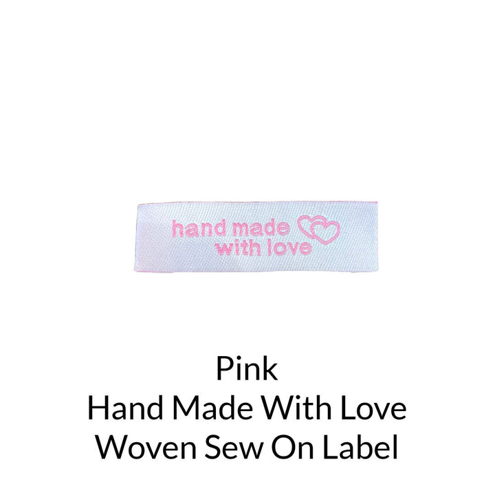 pink writing on white background woven sew on label