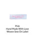 pink writing on white background woven sew on label
