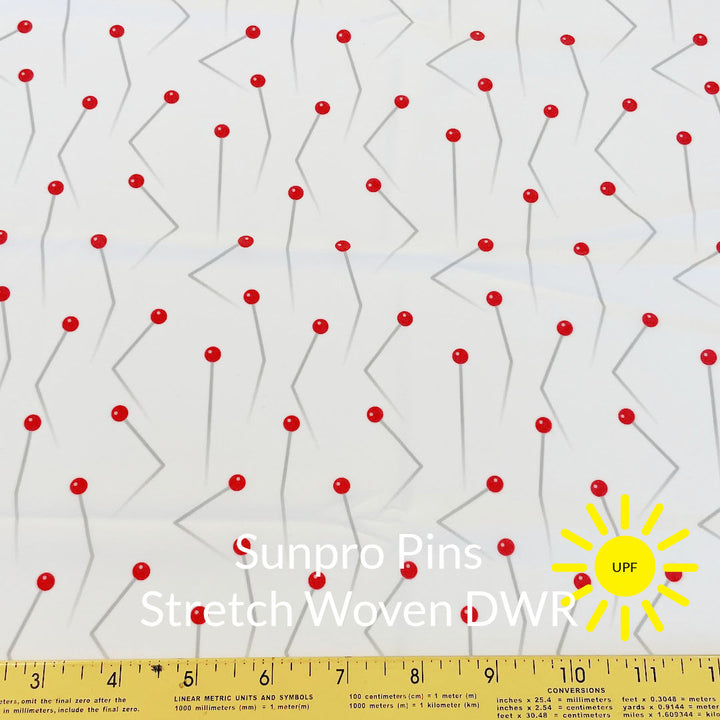 red and pale grey silver crooked push pins on white background sun pro sun protection stretch woven fabric